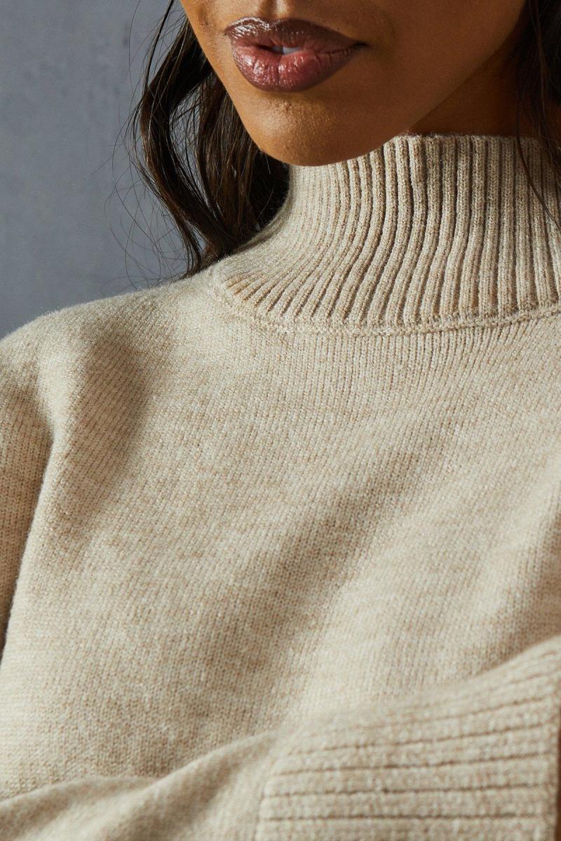 В'язаний перемичка з високою шиєю на шиї